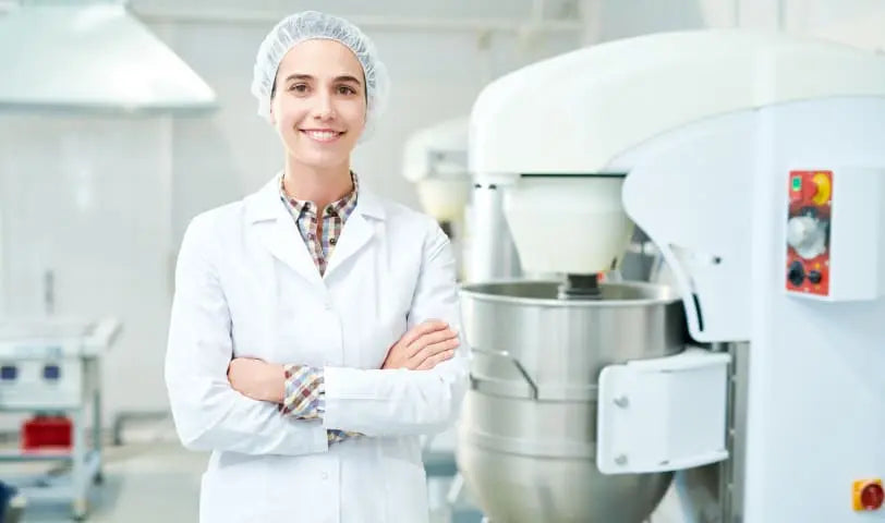 A smiling Loonawell worker standing in the Loonawell kitchen
