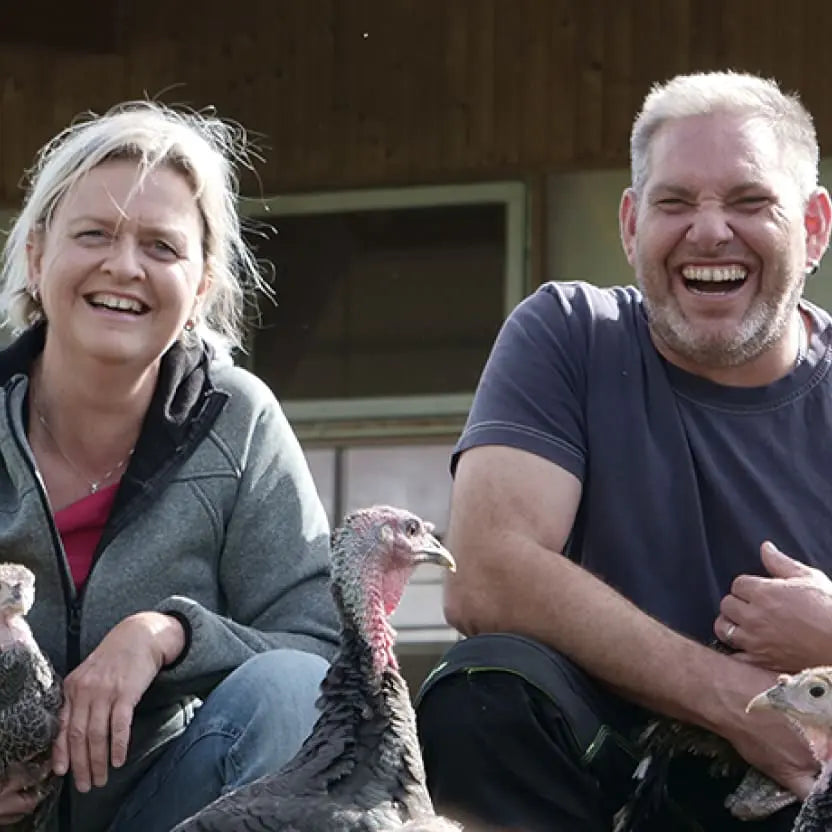 Famers laughing with their turkeys, from Free-Range Organic Turkey, Loonawell's organic turkey supplier