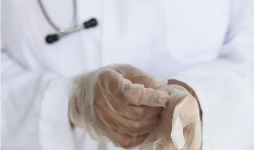 A close-up of a scientist putting on gloves before starting their work