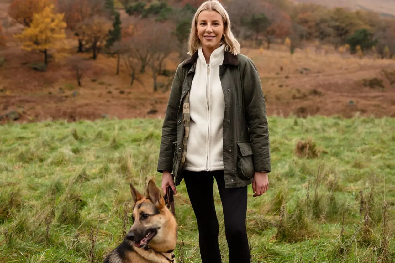Une propriétaire heureuse avec son chien satisfait lors d'une promenade après lui avoir donné des friandises pour chiens Loonawell's Organic Baked Dog Treats.
