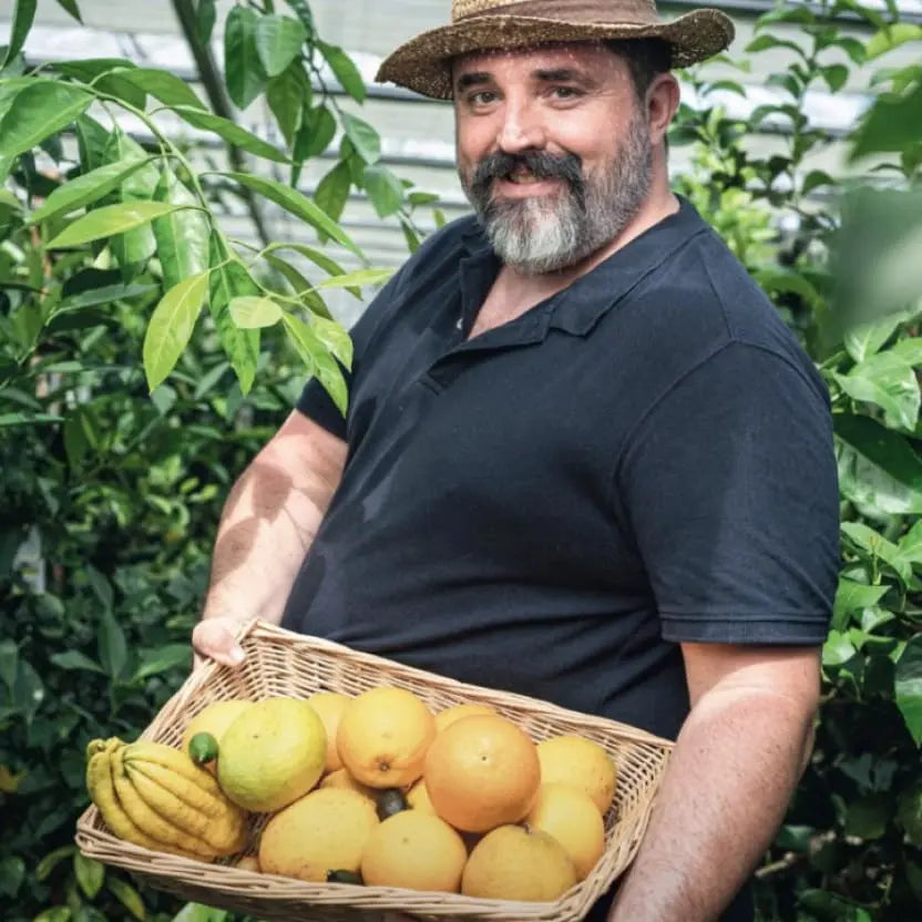Un agricoltore della Sinergia Culinaria degli Agrumi con un cesto di limoni