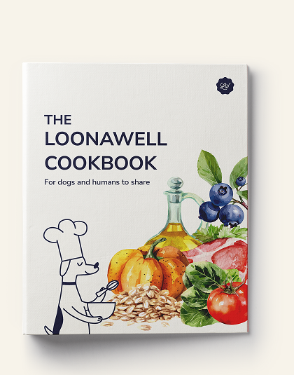 The front cover of 'The Loonawell Cookbook' is shown against a light beige background. The white cover features dark blue text and a whimsical black-and-white line drawing of a dog chef holding a bowl.