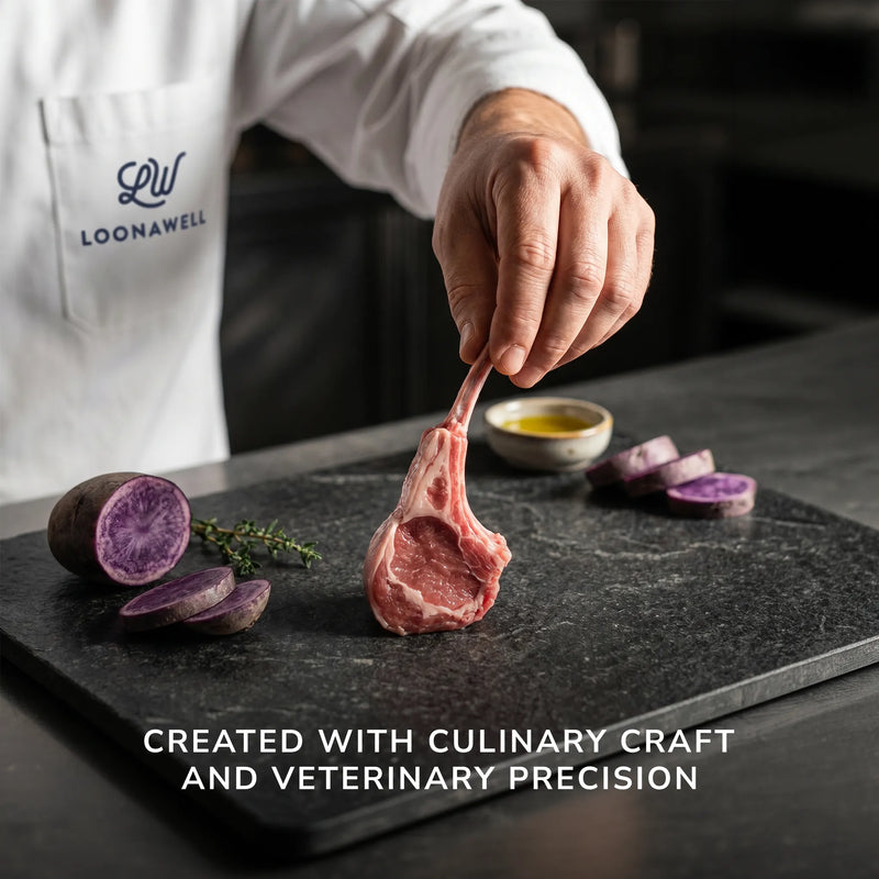 LOONAWELL chef holding a lamb chop with purple potatoes, olive oil and thyme on a slate board