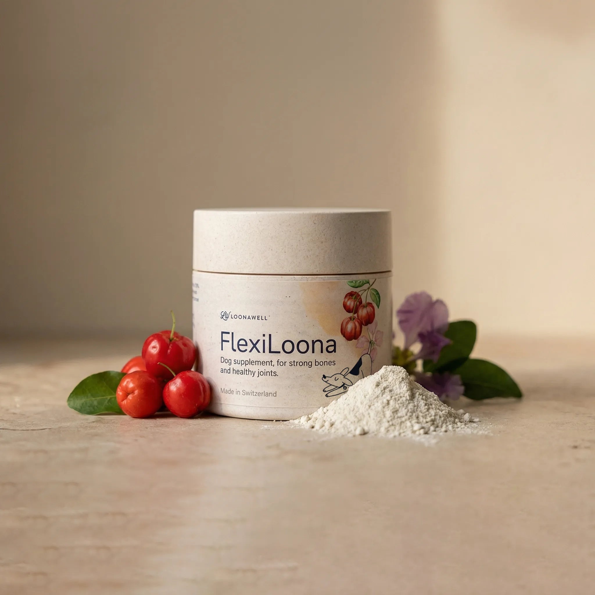 A tub of Loonawell FlexiLoona dog supplement for strong bones and healthy joints, displayed alongside a small pile of the powder, fresh acerola cherries, and purple flowers.